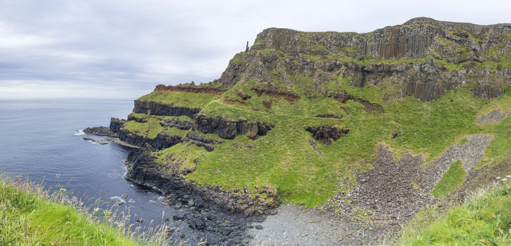 Blick am Giants Causeway auf die Organ Pillars und den Sentinel oberhalb des Amphitheater Viewpoints, Irland, Juni 2023.