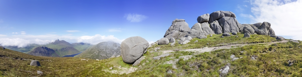 In den Mourne Mountains im County Down - Vom Slieve Binnian (747m) über den Slieve Binnian North (660m) mit der Granitfels-Formation des Nord-Tors und Blick auf das Ben Crom Reservoir und den Slieve Lamagan (756m), Irland, Juni 2023.
