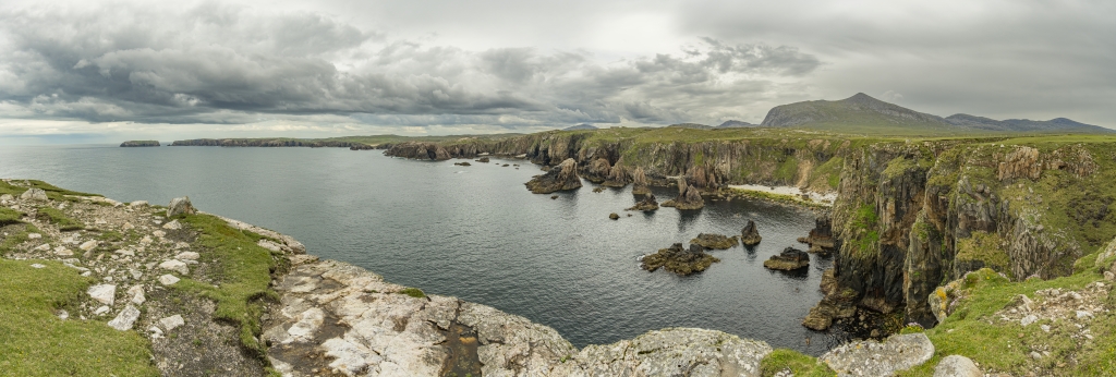 Bucht im Westen der Isle of Lewis mit den Mangersta Sea Stacks vor dem hohen Gipfel des Mealaisbhal (574m), Isle of Lewis, Schottland, Mai 2024.