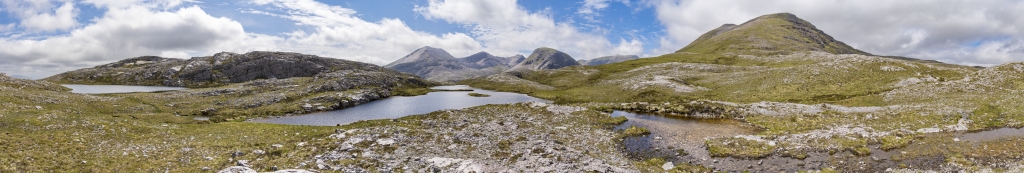 Panorama am Loch Allt An Daraich auf dem Beinn Eighe Mountain Trail mit Blick auf die umliegenden Gipfel Leathad Buidhe (557m), den langen Kamm des Beinn Eighe mit den Gipfeln Greag Dhubh(929m), Sgurr An Fhir Dhuibhe (963m), Sgurr Ban (970m) und Spidean Coire Nan Clach (977m), dem Ruadh-Stac Beag (896m), Ruad-Stac Mor (1010m) und Sail Mor (980m) sowie dem Doppelgipfel des Meall a Ghiubhais (887m), Torridon Mountains, Schottland, Juni 2024.