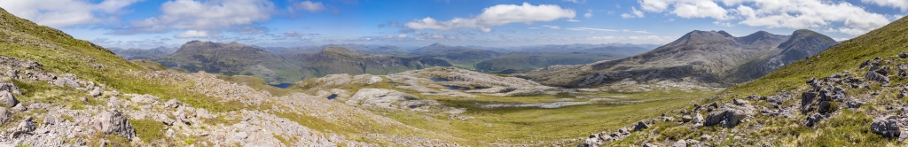 Im Abstieg vom Gipfel des Meall a Ghiubhais (887m) eröffnet sich noch einmal ein weiter Rundumblick auf den auf der Ostseite des Loch Maree gelegenen Slioch (981m), den flachen Gipfel des Beinn a Mhunidh (680m), die unter uns liegende Hochfläche mit dem Loch Allt An Daraich und dem Leathad Buidhe (557m), den Ort Incheril und den dahinter in der Ferne aufragenden Gipfel des Fionn Bheinn (933m) sowie den gegenüberliegenden langgestreckten Kamm des Beinn Eighe Massivs, Torridon Mountains, Schottland, Juni 2024.