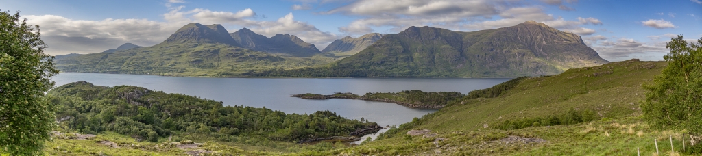 Im beginnenden Abendlicht am Torridon Viewpoint mit Blick auf den Upper Loch Torridon und die sich darüber erhebenden Gipfel des Beinn Alligin Massivs mit Tom na Gruagaich (922m) und Sgurr Mor (986m), des Beinn Dearg (914m) und des langgestreckten Kamms des Liathach (1053m), Torridon Mountains, Schottland, Juni 2024.