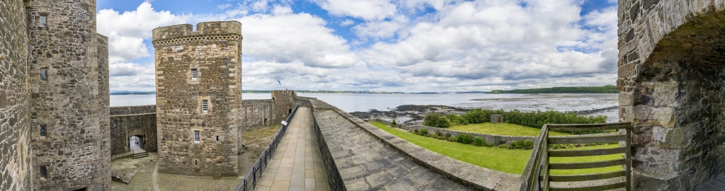 Blackness Castle aus dem 15. Jahrhundert mit Blick auf den Firth of Forth und die in der Ferne sichtbaren Highway- und Eisenbahn-Brücken nach Edinburgh, Schottland, Juni 2024.