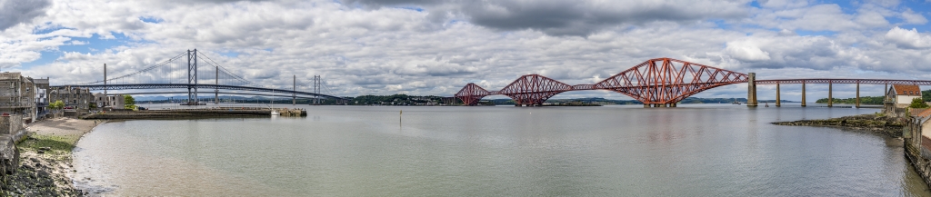 Firth of Forth bei South Queensferry mit den mittlerweile zwei Highway-Brücken und der historischen roten Metallkonstruktion der Eisenbahn-Ausleger-Brücke nach Edinburgh aus dem Jahr 1890 mit einer Spannweite von 2523m und einer Höhe von 46m, Schottland, Juni 2024.