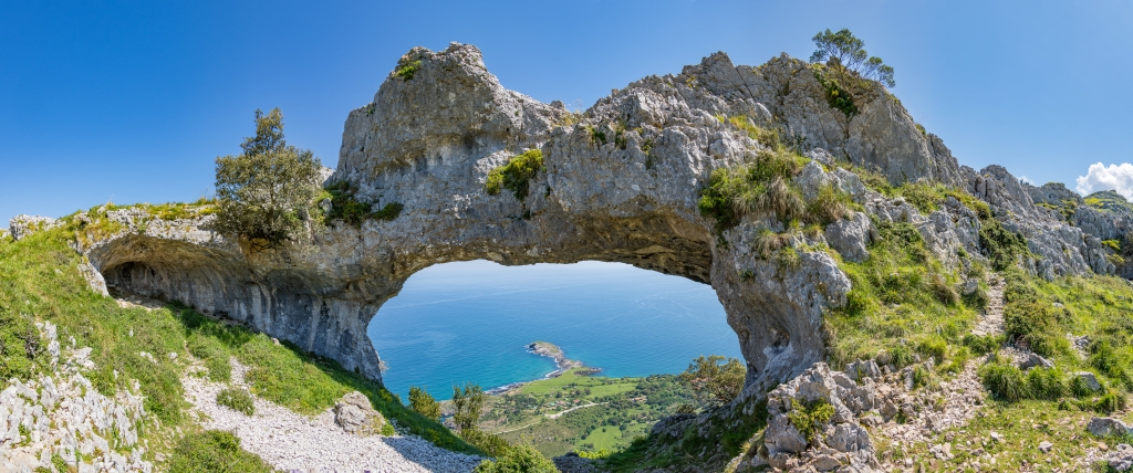 &Uuml;ber dem Playa de Sonabia erheben sich &uuml;ber 400m hohe Kalkw&auml;nde mit den Felsenl&ouml;chern der Ojos del Diabolo, Nordspanien, Mai 2025.